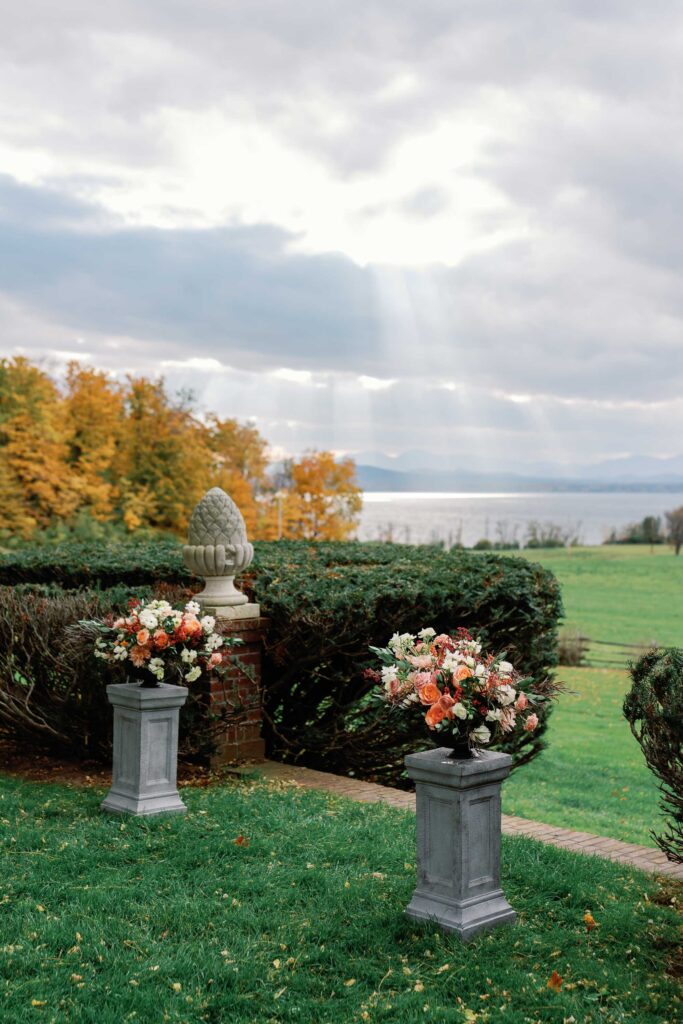 fall wedding ceremony florals with sun shining on lake champlain at brick house shelburne museum vt