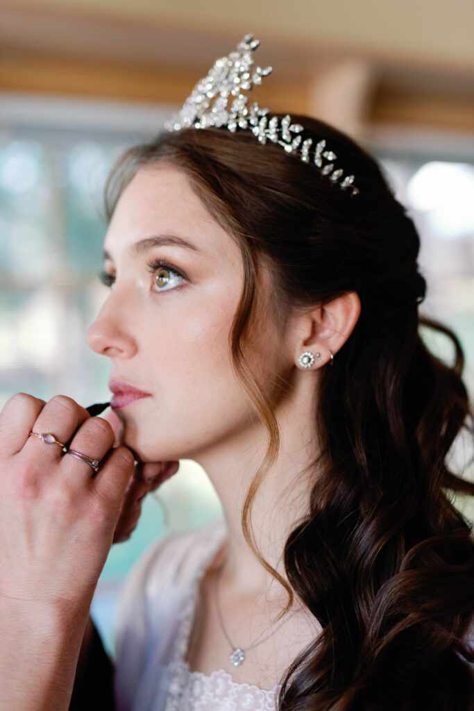 bride getting hair and make up for black tie wedding with tiara by jennifer behr