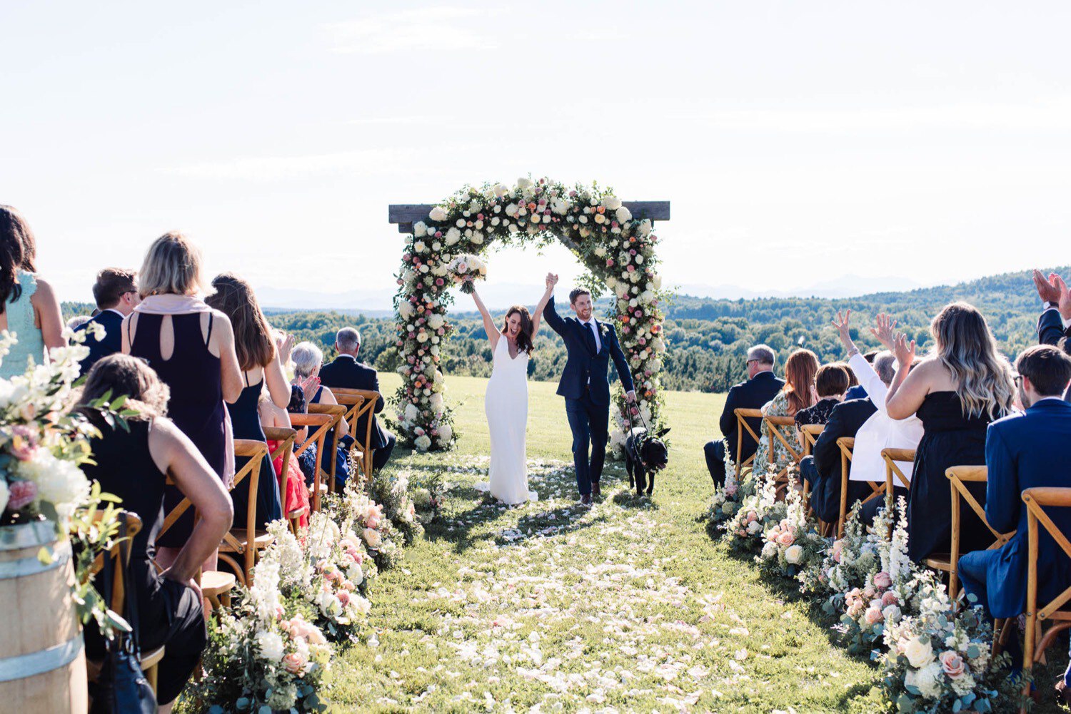 Newlyweds celebrate during recessional, outdoor wedding ceremony