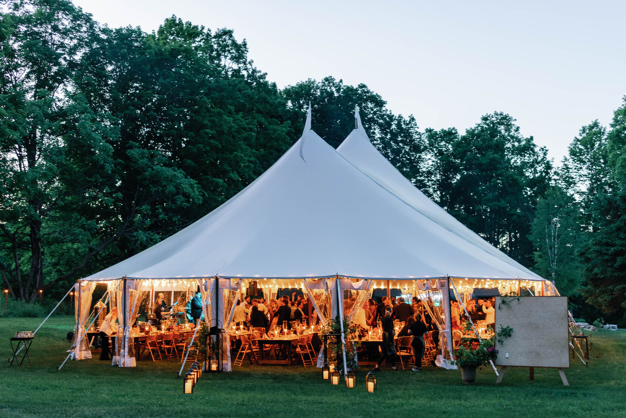 a lively wedding reception, outdoors, under a large white tent - heartfelt guest experience