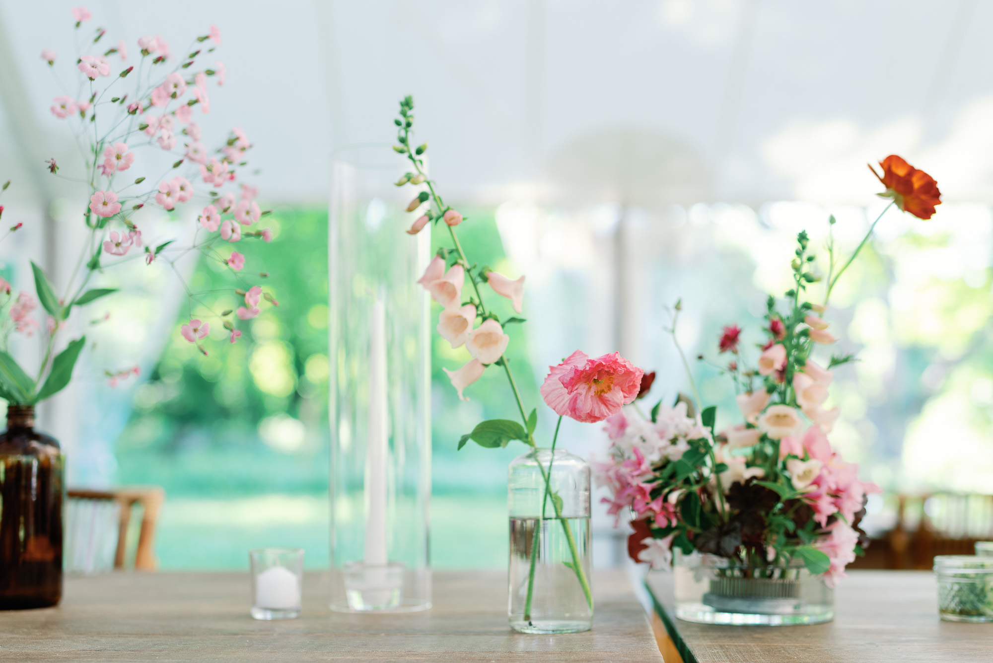 pink wedding florals by nectar and root at tented wedding reception in summer