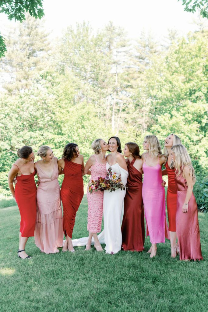 mismatched bridesmaids in pink and red hug bride including supermodel emma ostilly