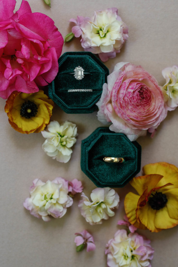large diamond vrai wedding ring on emerald ring boxes with bright pink flowers