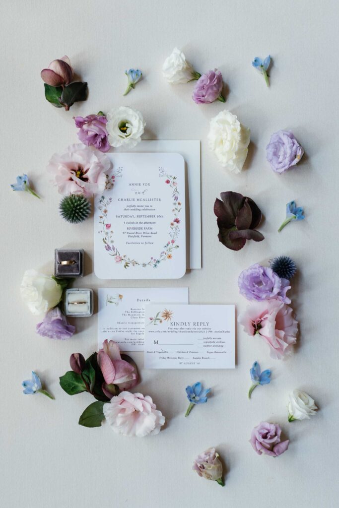 floral display of pastel flowers for fall wedding invitation with elegant pinks, blues and plumb tones