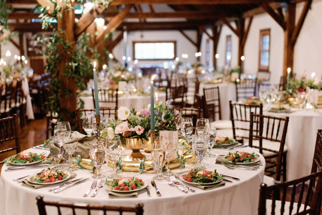 elegant riverside farm reception space with white table cloths, blue candlesticks and salads on the tables