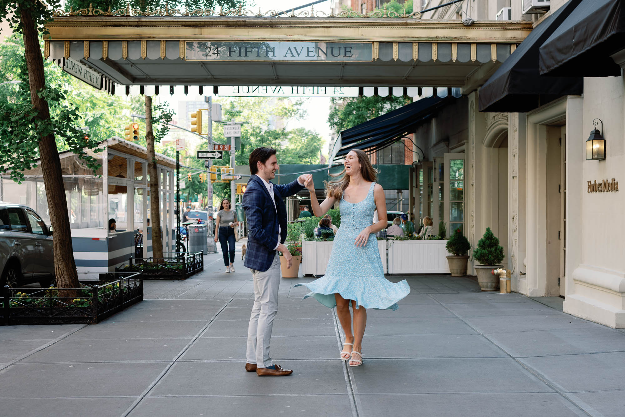 fifth avenue engagement session couple twirls on the streets of the west village